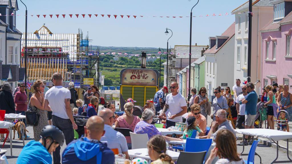 Nansledan in Cornwall on a summer day with tables out in the street