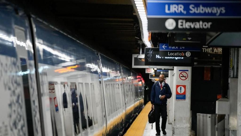 A railway worker walks along a deserted platform in New York