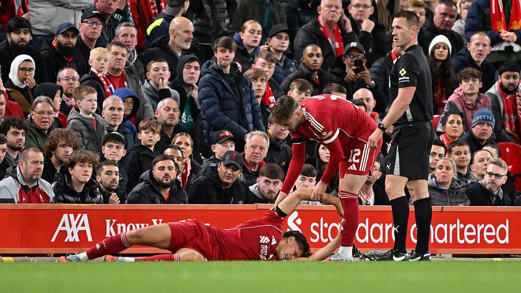 Liverpool's Giovanni Leoni clutches his knee at Anfield