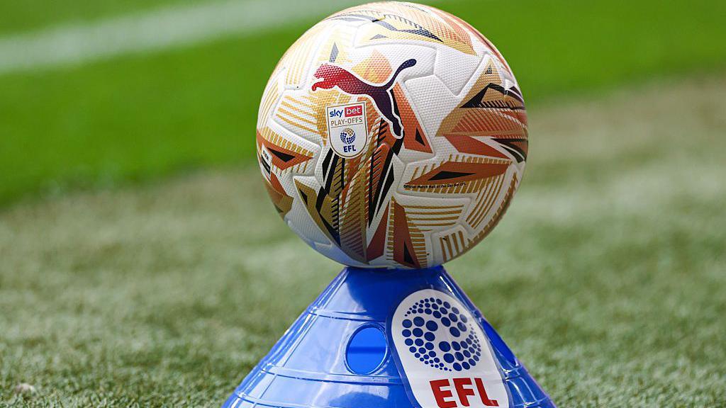 An EFL football with goal design perched on top of a blue cone with EFL branding on it