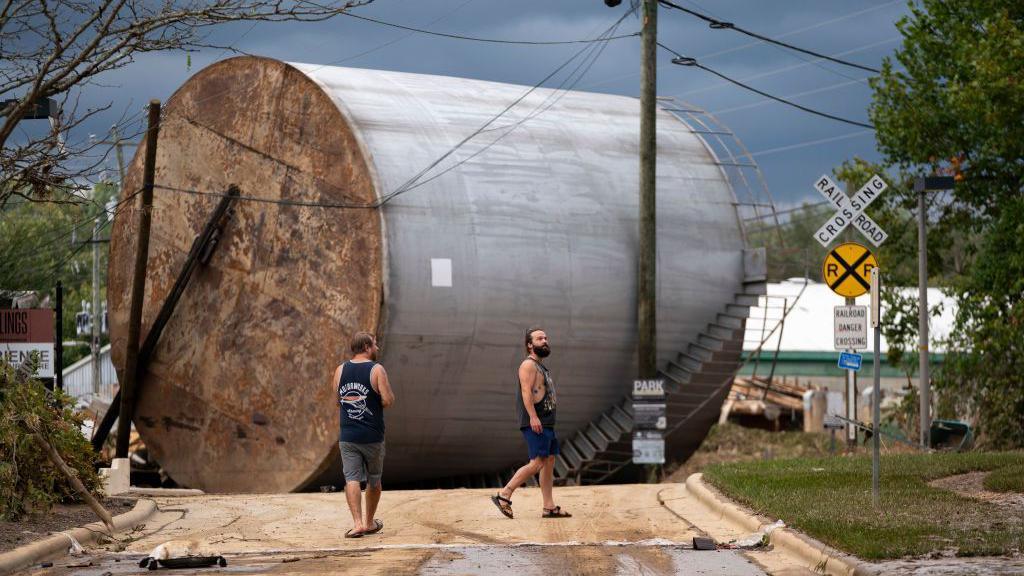 Men survey the destruction from Helene in Asheville, North Carolina