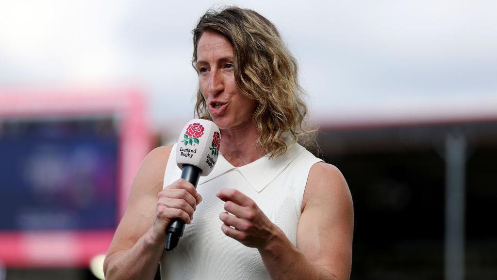 Kat Merchant speaking into a microphone.