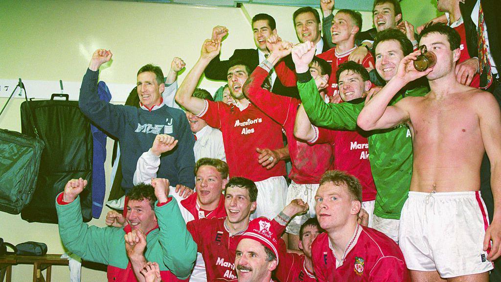 The Wrexham team celebrate in the dressing room after the win over Arsenal