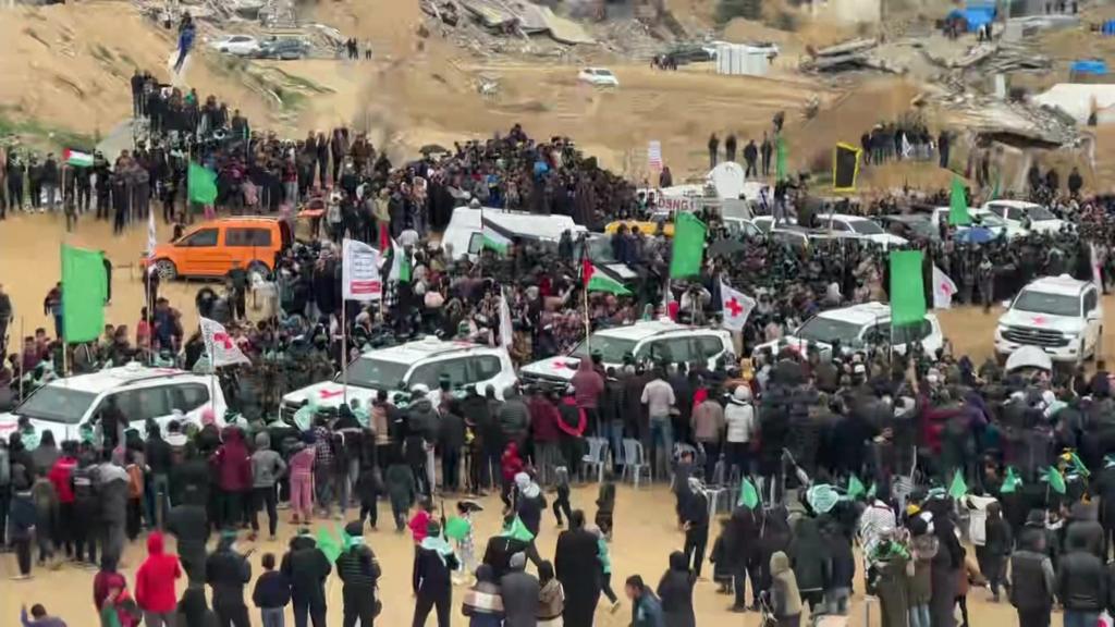 Red Cross convoy surrounded by crowds