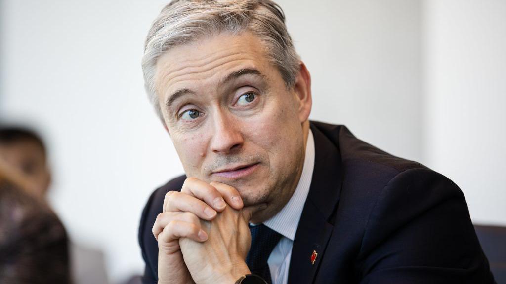 François-Philippe Champagne, Minister of Innovation, Science and Industry of Canada wearing a dark suit rests his chin on his hands while sitting during an interview 