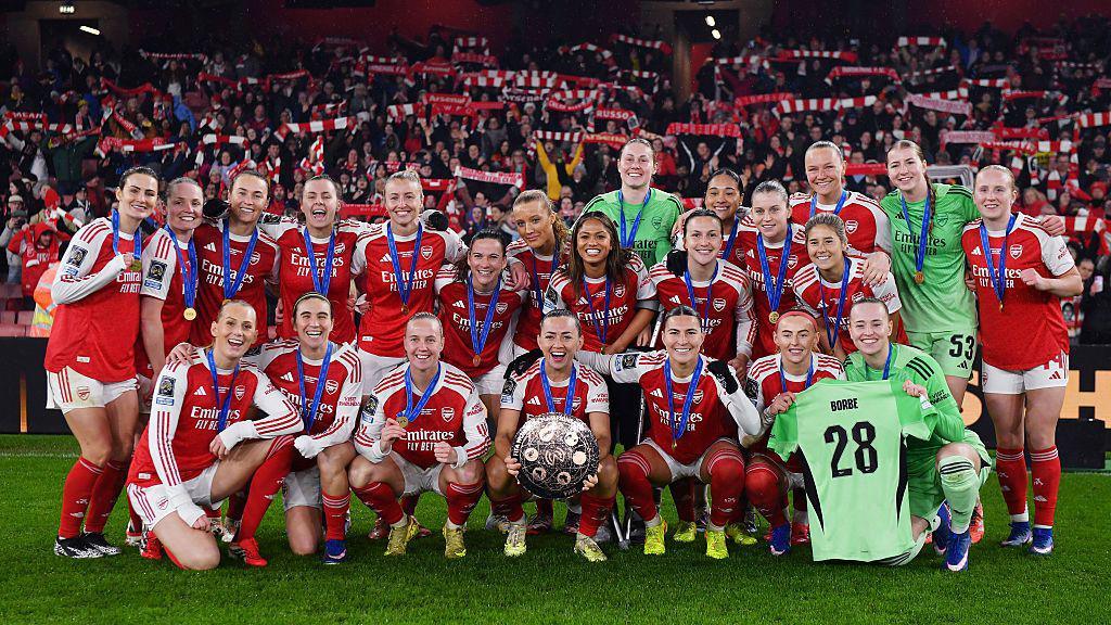 Arsenal players celebrating with the Women's Champions Cup Trophy.