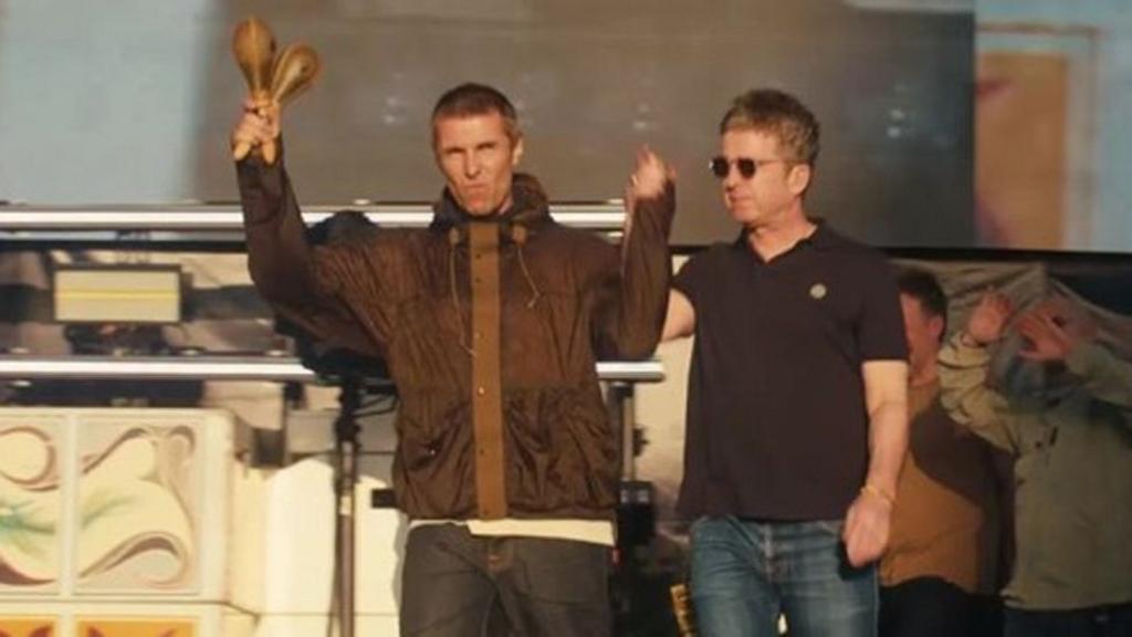 Liam and Noel Gallagher hand-in-hand arrive on stage