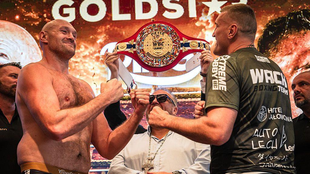 Tyson Fury and Mariusz Wach hold up their hands and face each other