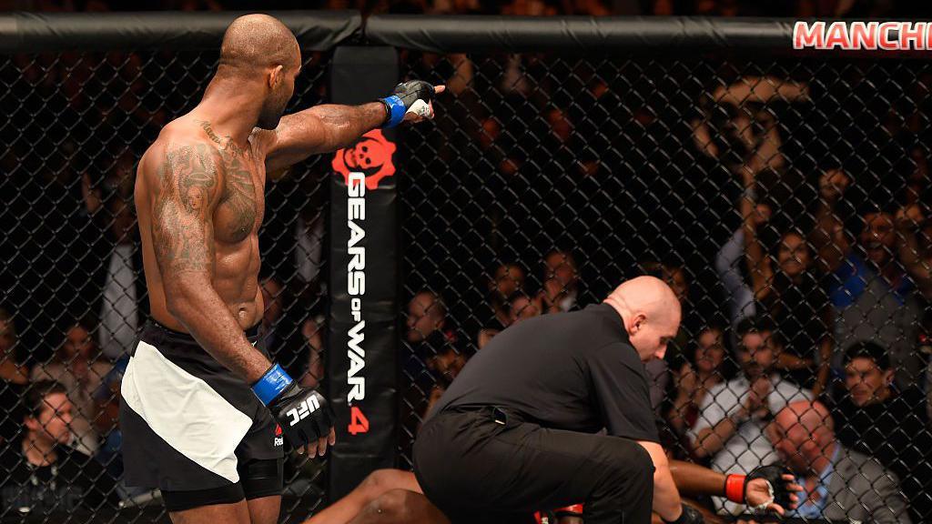 Jimi Manuwa points into the crowd with his opponent on the canvas