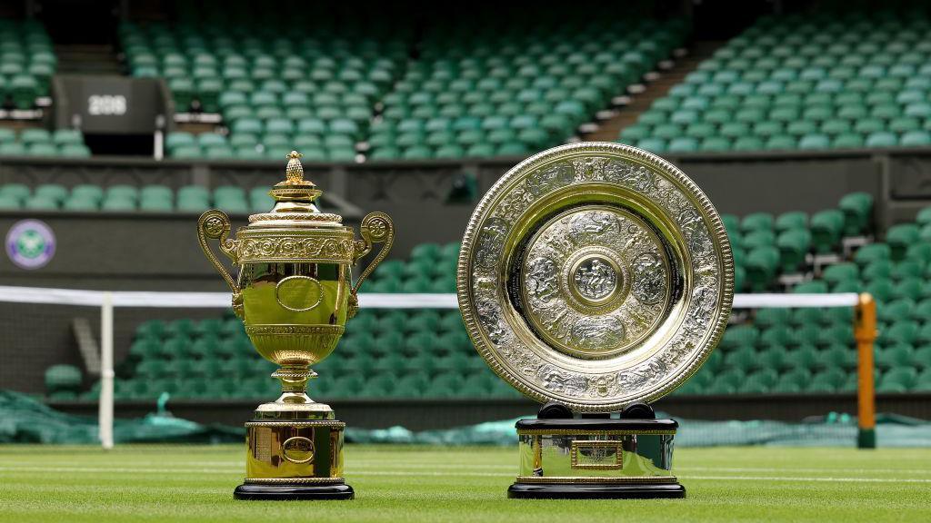 Wimbledon men's and ladies' trophies on court.