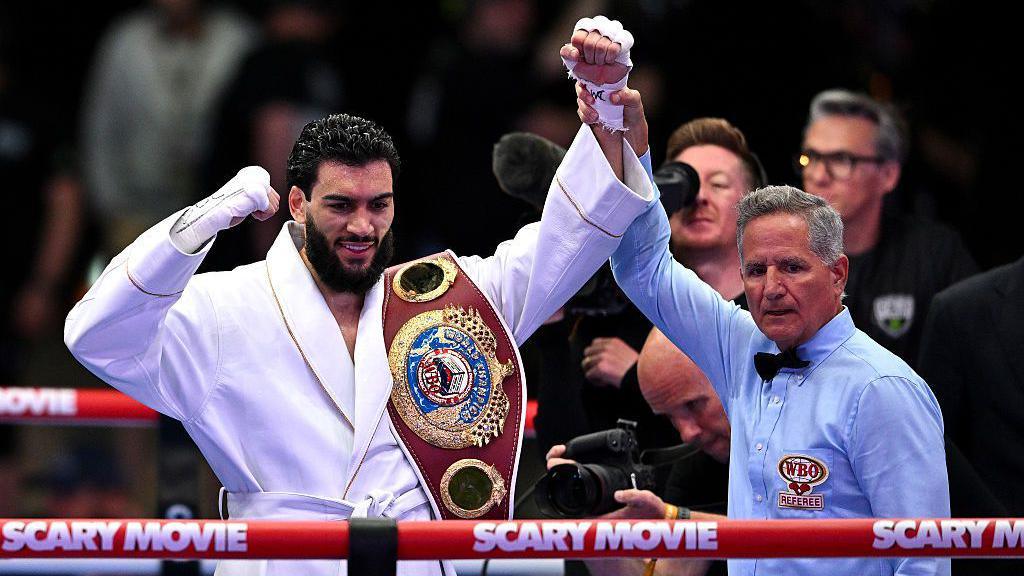 Hamzah Sheeraz is holding his world title with his hand in the air