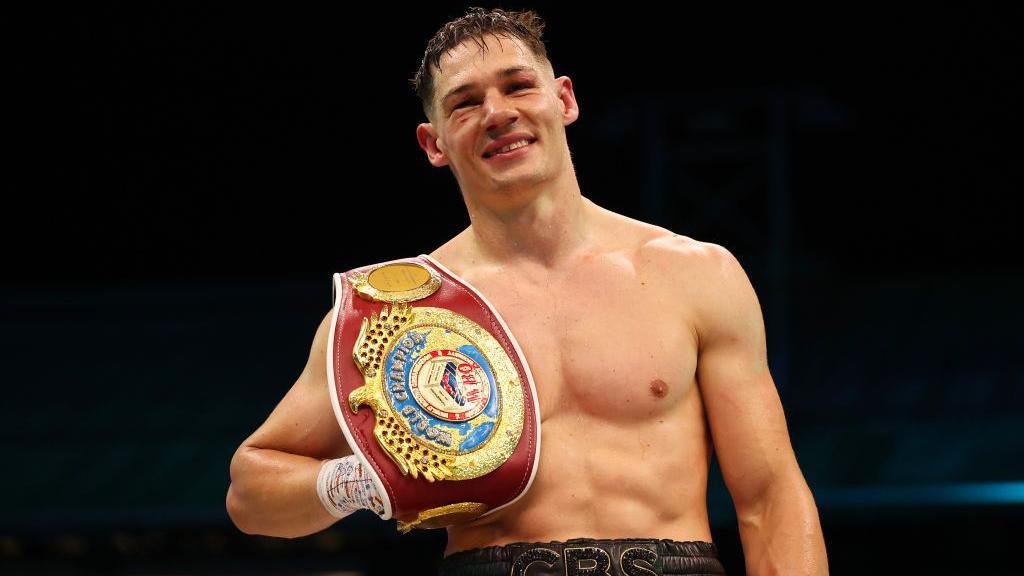 Chris Billam-Smith holding his WBO cruiserweight belt 