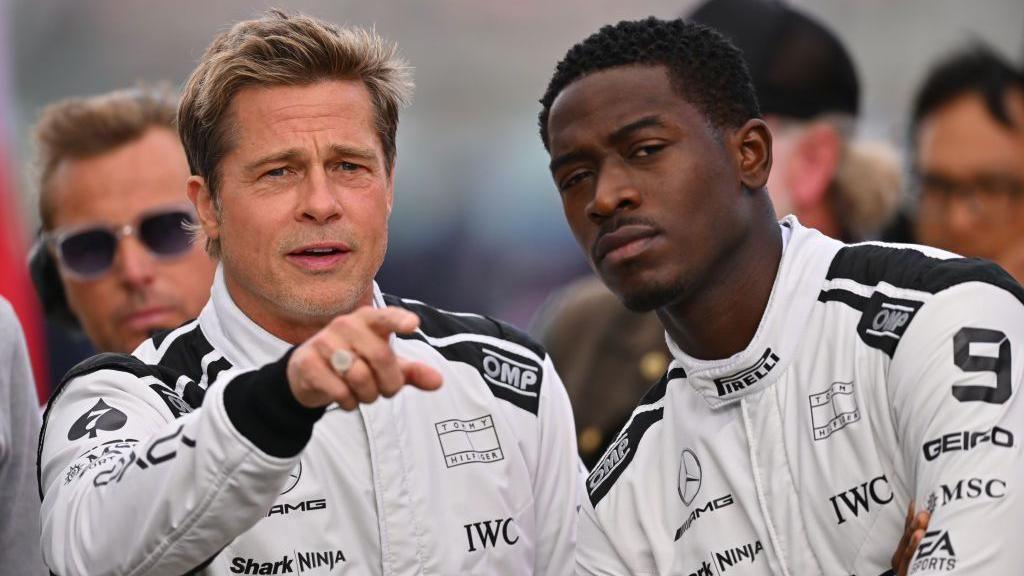 Brad Pitt points standing next to F1 co-star Damson Idris