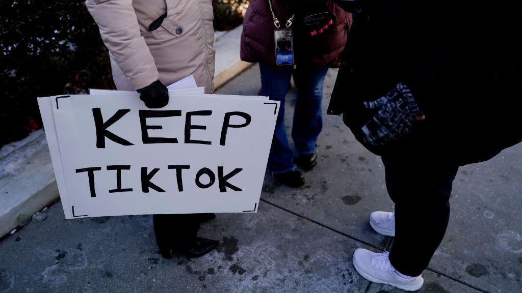 A shot of the feet of protesters holds a "Keep TikTok" sign outside the US Supreme Court