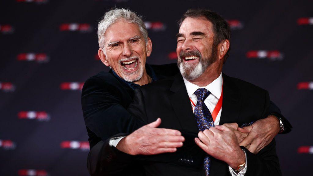 Former F1 champions Damon Hill and Nigel Mansell with their arms round each other as they share a joke