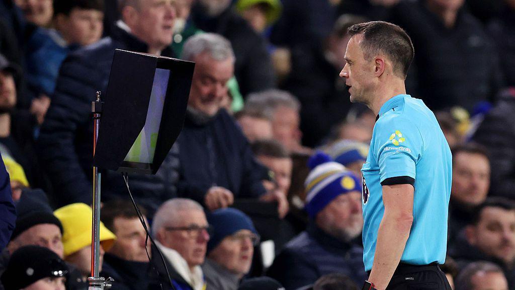 Referee Stuart Attwell checks the VAR screen during the Premier League match between Leeds United and Sunderland on Tuesday