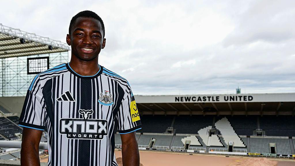 Bazoumana Toure poses for photographs wearing the new Newcastle shirt at an empty St James' Park