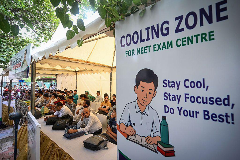 Parents of NEET candidates wait at a cooling station outside an examination centre in Delhi 