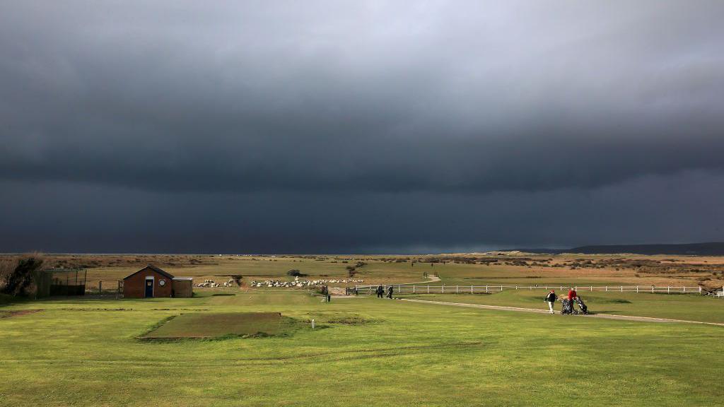 Golfers walk to the clubhouse from the 18th green in Bideford