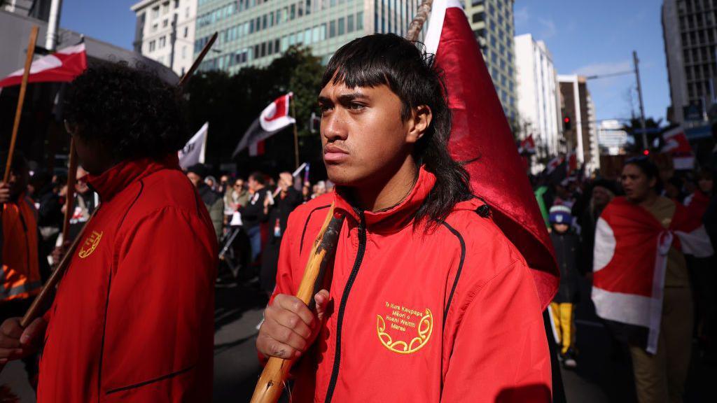 A young man holds a flag during a protest