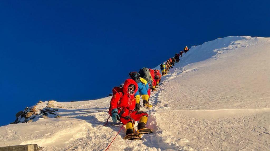 People climbing up Mount Everest in the snow