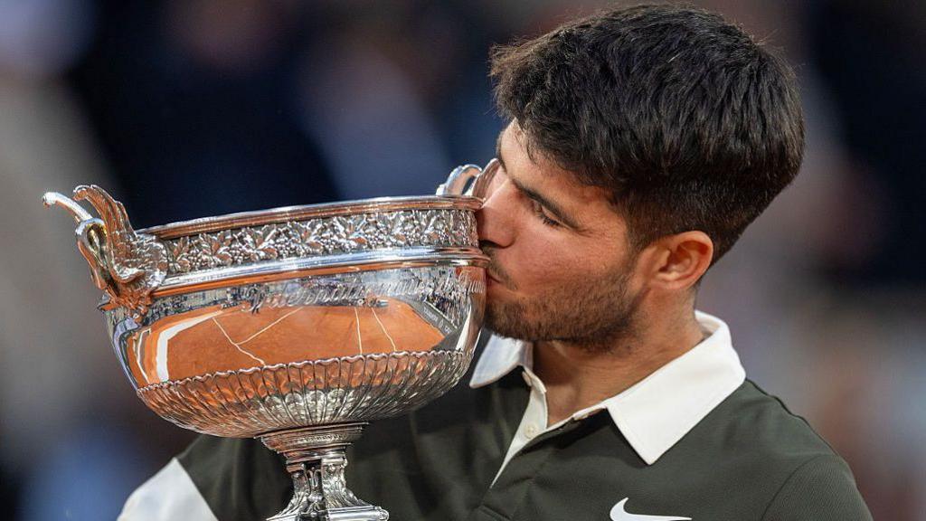Carlos Alcaraz kisses the French Open trophy