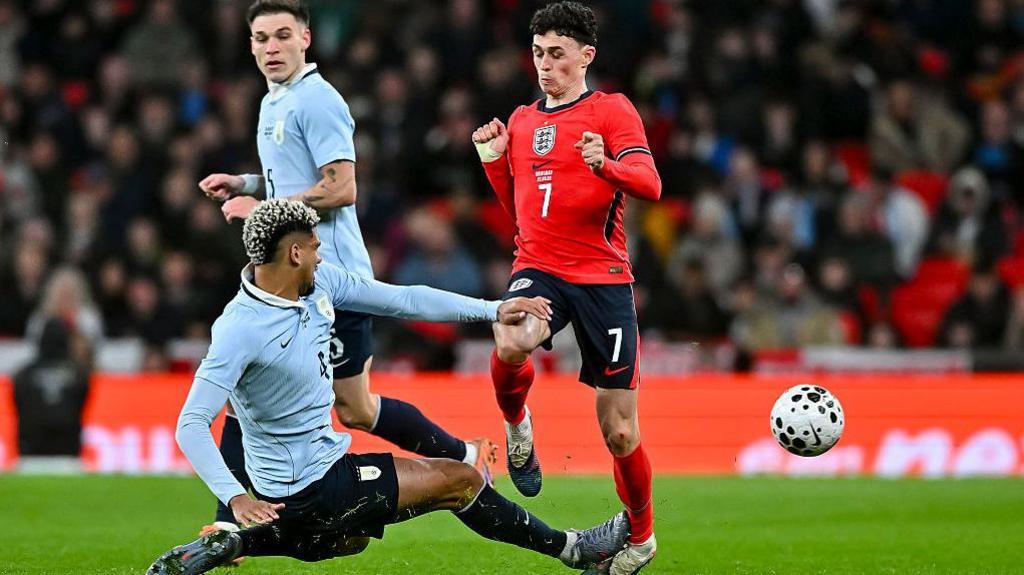 Ronald Araujo goes to tackle England's Phil Foden