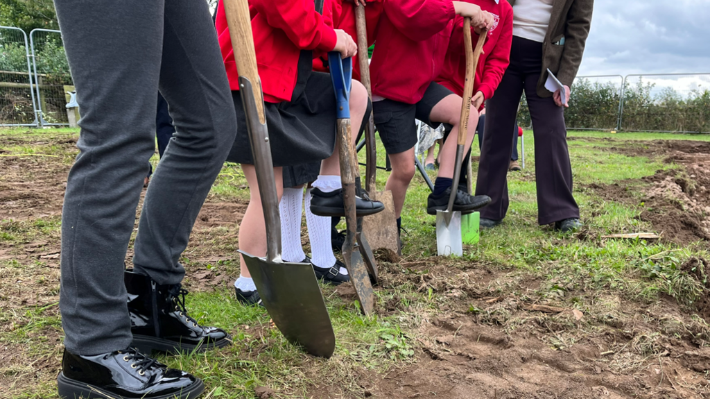 School children holding spades for the ceremonial first dig.