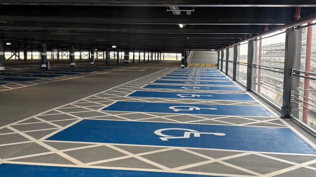The inside of an airport car park with multiple accessible parking bays marked in blue.