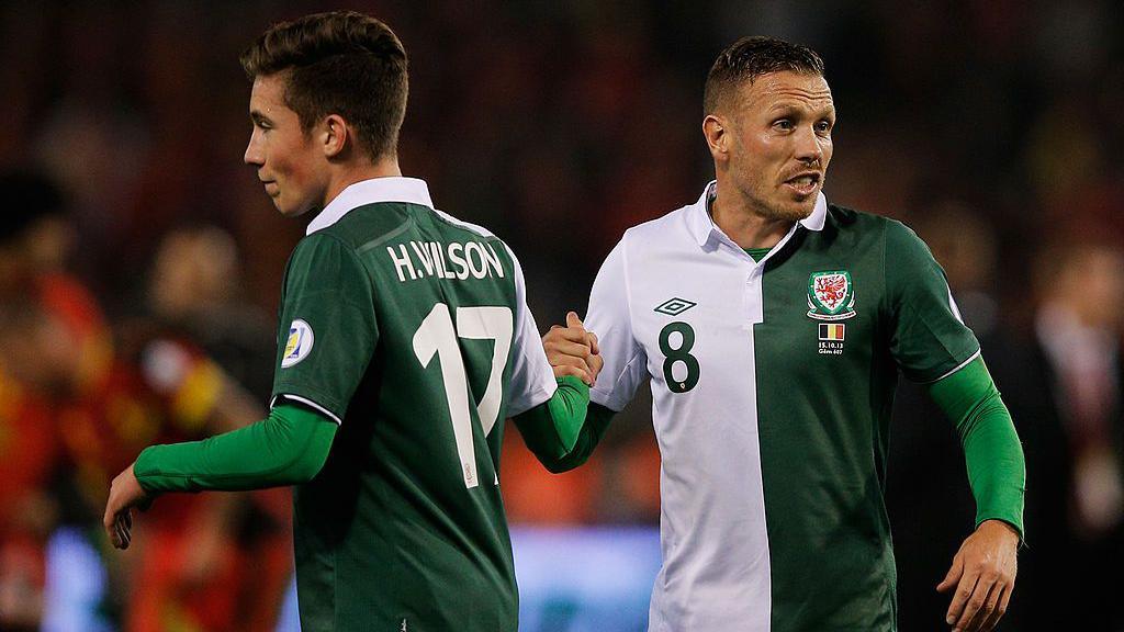 Craig Bellamy and Harry Wilson of Wales shake hands during the World Cup qualifying match in Belgium at King Baudouin Stadium on October 15, 2013 