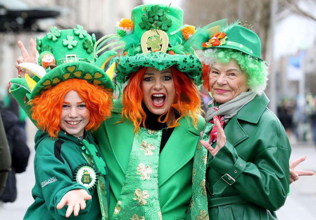 Three people wearing green outfits and orange wigs to celebrate St Patrick's Day in Dublin. 