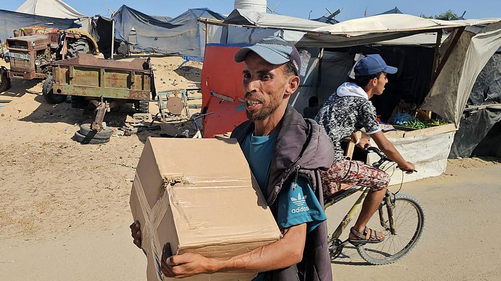 Some Palestinians were seen holding food parcels bearing the GHF logo in western Rafah, in the southern Gaza Strip (27 May 2025)