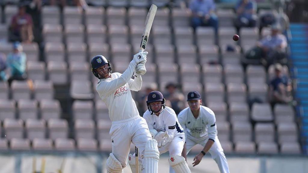 Graham Clark of Durham pulls to the legside as Hampshire wicketkeeper Ben Brown looks on