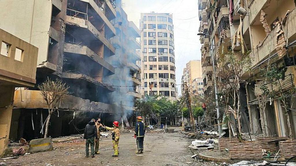 Firefighters and rescuers assess the site of an Israeli airstrike on a residential blocks in Beirut's southern suburb of Haret Hreik .