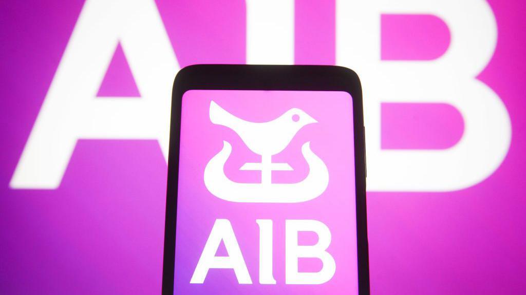 AIB logo on a phone against a hot pink background