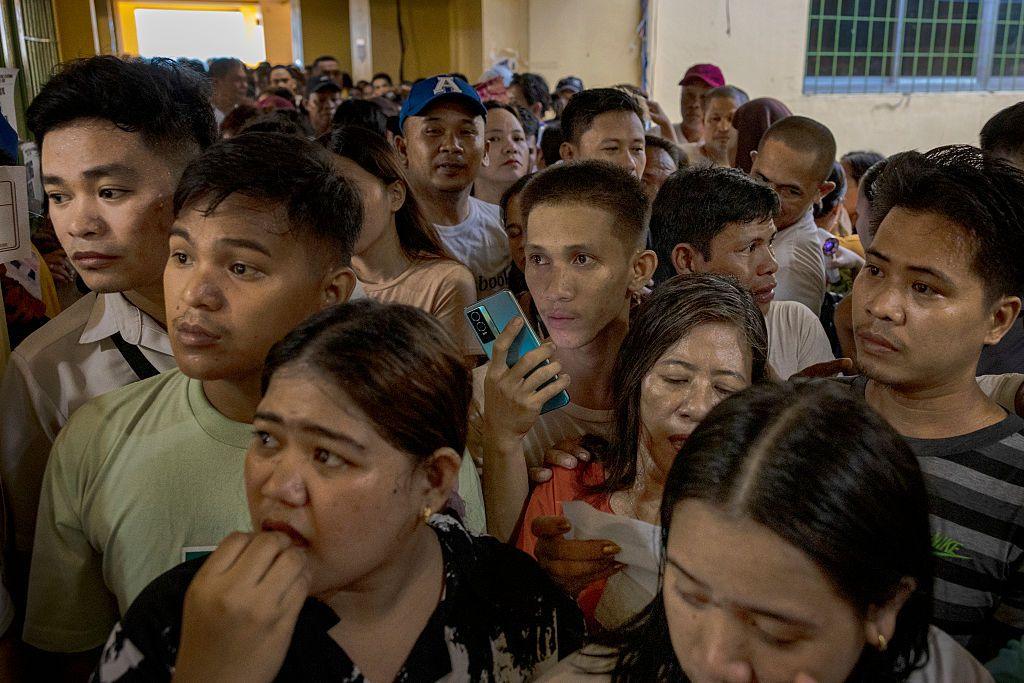A tightly packed crowd of nervous-looking people