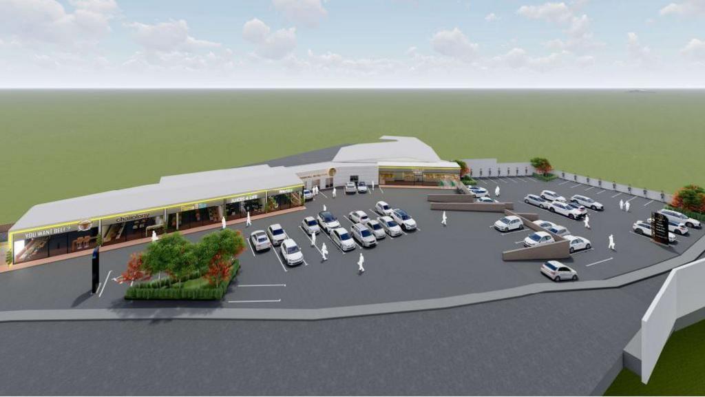 An artists' impression showing a single storey building and a car park. The single-storey building is separated into restaurants and a shop. The car park has a grey floor and white cars parked in it. There is also a small grassy area with trees growing in the corner of the car park.