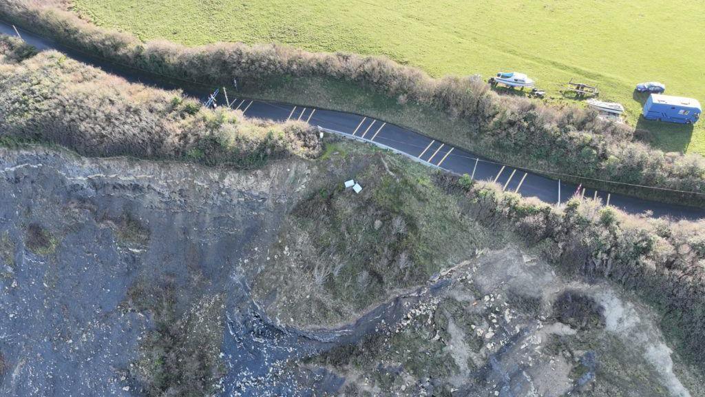 Aerial image of coastal road falling into the sea. 