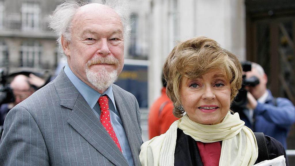 Timothy West and Prunella Scales photographed in 2006.  They are smiling and looking to camera.  They are formally dressed.