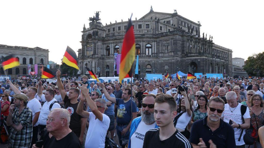 Supporters of the far-right Alternative for Germany (AfD) political party gather with German flags in front of the Semperoper opera house at the final AfD Saxony election rally prior to state elections on August 29, 2024 in Dresden, Germany