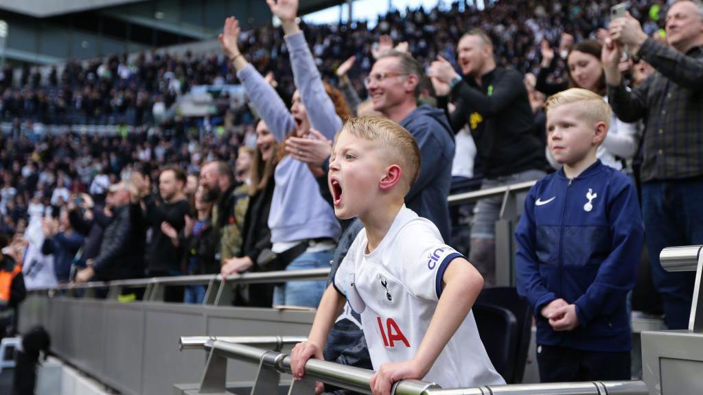 A young Tottenham fan shouts to try and get the attention of the players 