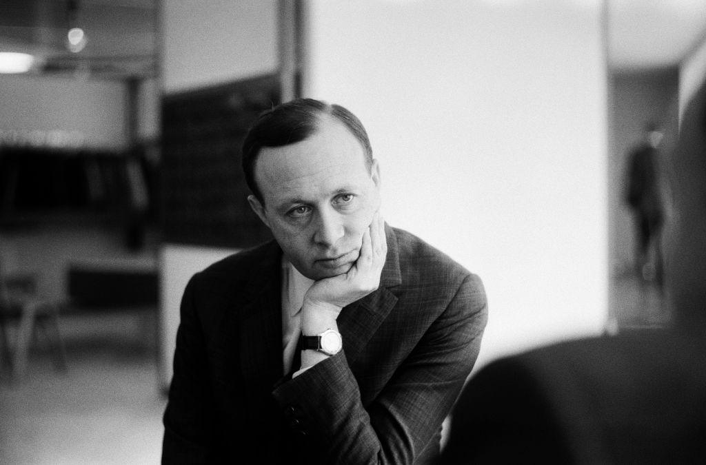 A black and white picture of Bernat Klein - a man with dark hair in a suit looking pensive