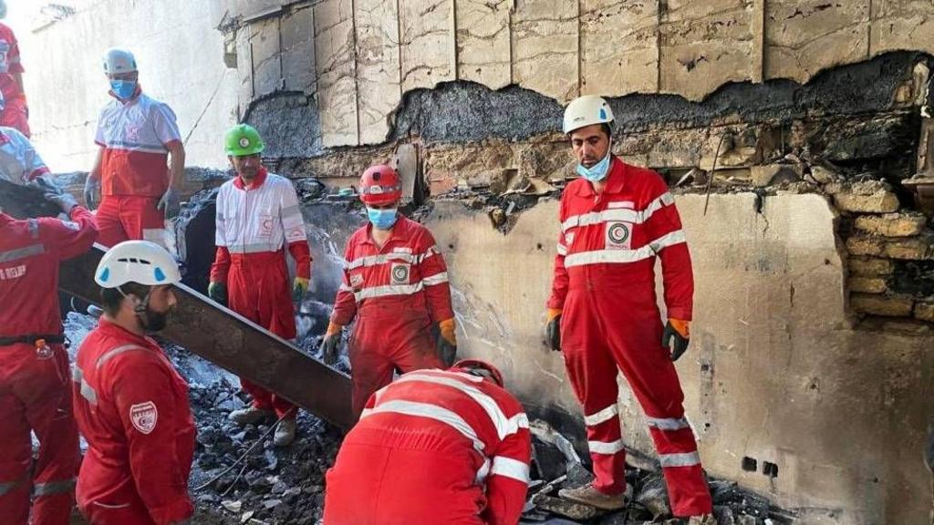 Iranian Red Crescent Society members search through the rubble for victims after Israeli strikes, at an unspecified location in Iran, 