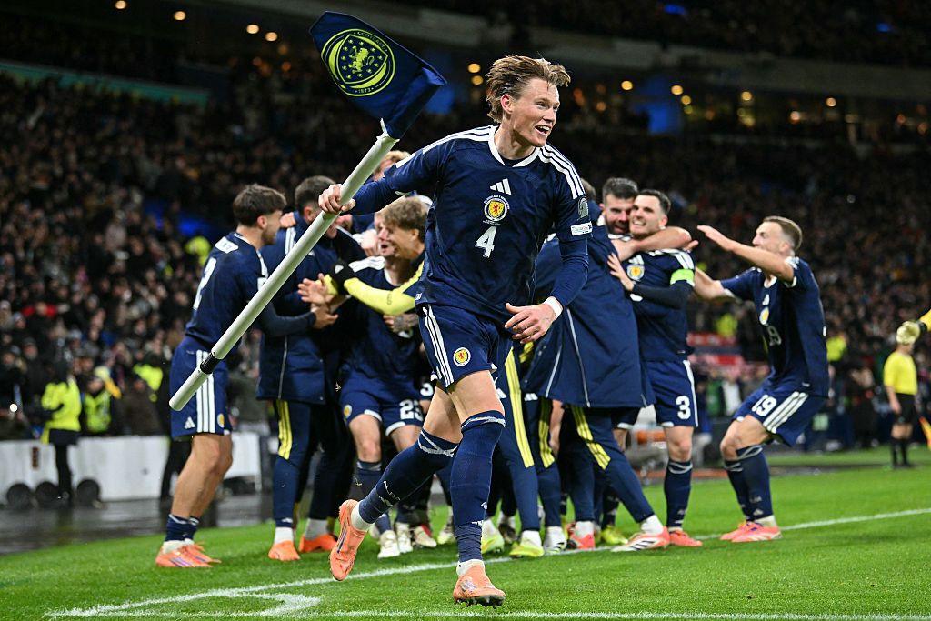 Scott McTominay of Scotland celebrates his team's fourth goal scored by Kenny McLean of Scotland, by lifting the corner flag emblazoned with the Scottish crest.