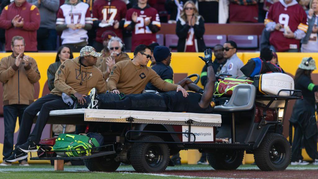 Efe Obada is carted from the field after getting injured while playing for the Washington Commanders against the New York Giants