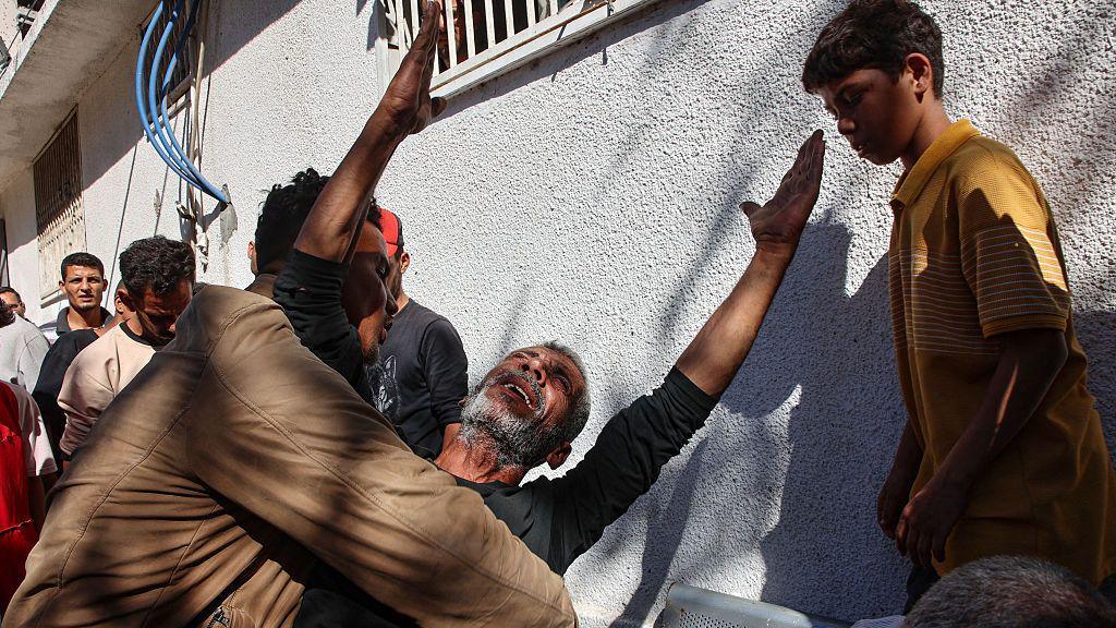 A Palestinian man reacts following an Israeli strike on Gaza City's Thailandy restaurant and its vicinity on 7 May 2025