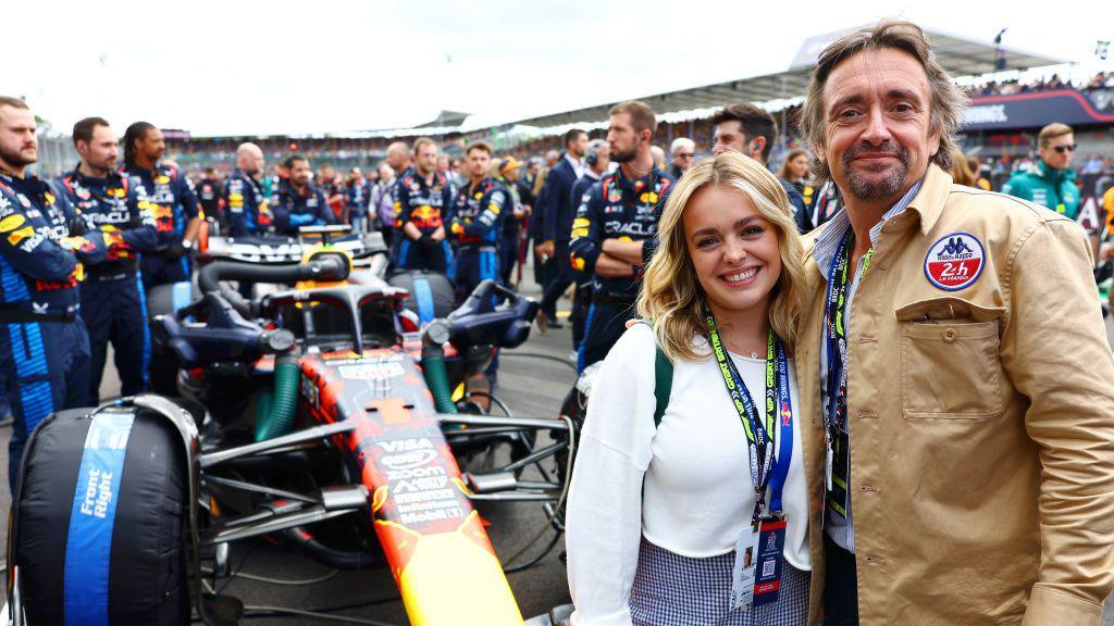 Izzy and Richard Hammond posing for a photograph next to Max Verstappen's Red Bull Formula 1 car ahead of the British Grand Prix in July 2024.