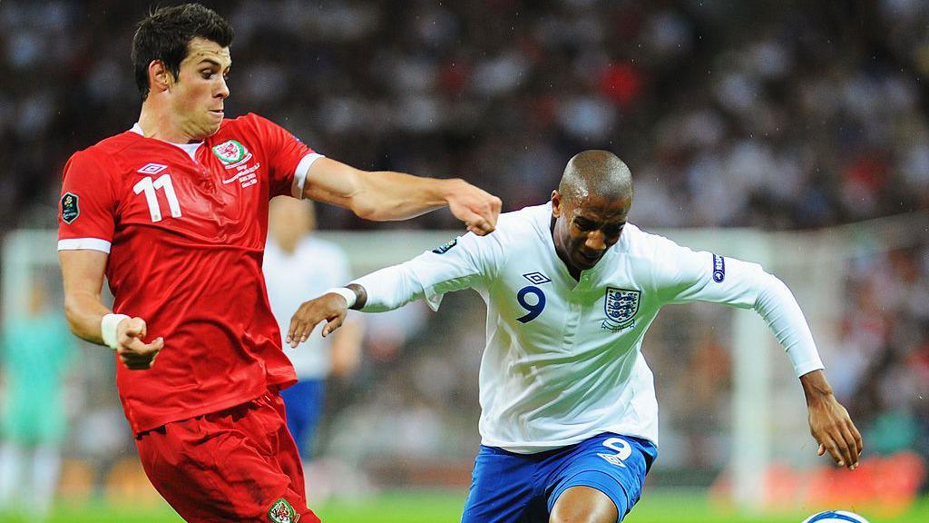 Gareth Bale of Wales challenges Ashley Young 