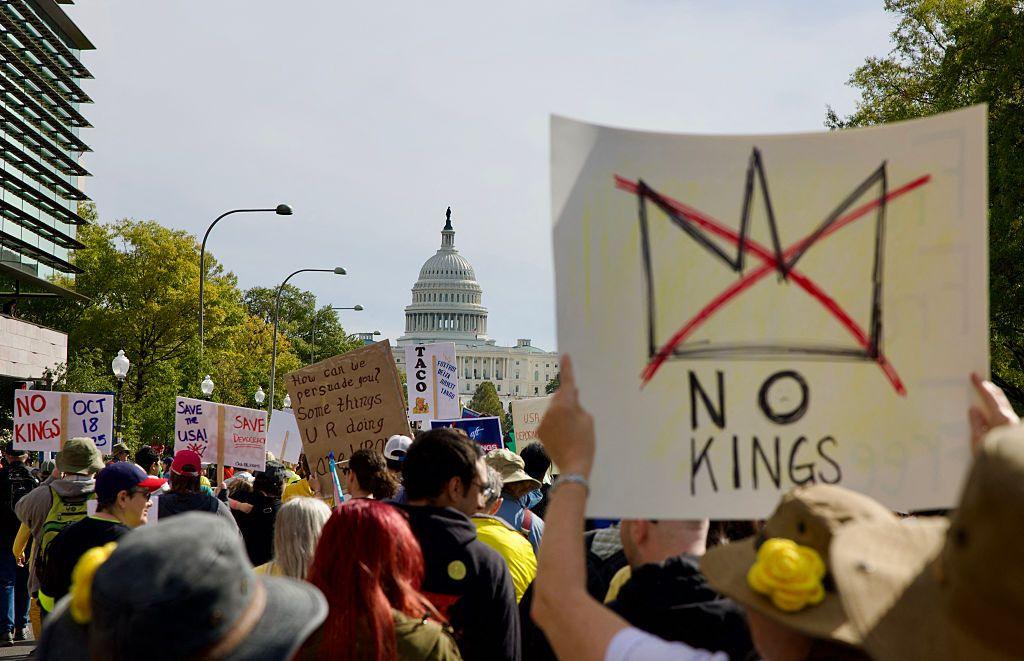 Protesters march outside the Capitol building in Washington, DC. One person carries a sign that reads "No Kings".