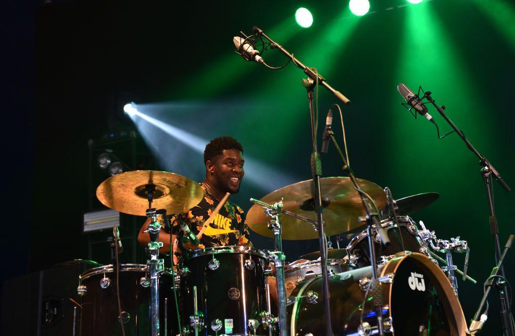 Femi Koleoso of Ezra Collective plays drums live on stage at the 2018 Womad Festival